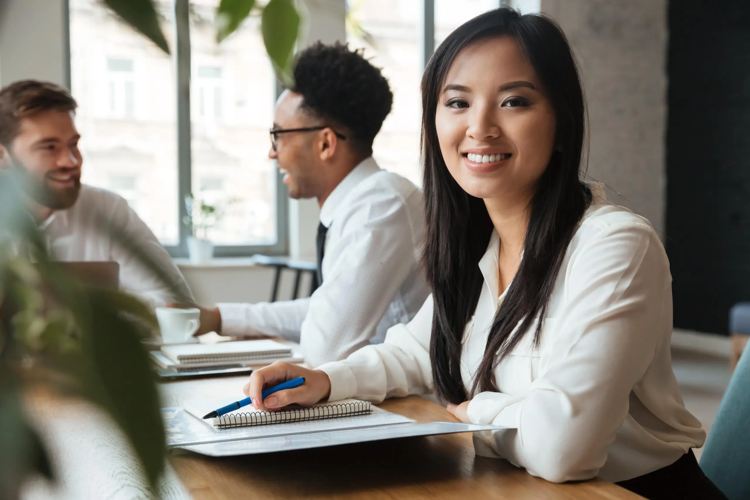 cheerful young asian businesswoman near colleagues (1)