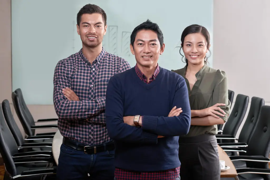 confident business team standing arms folded conference room (1)