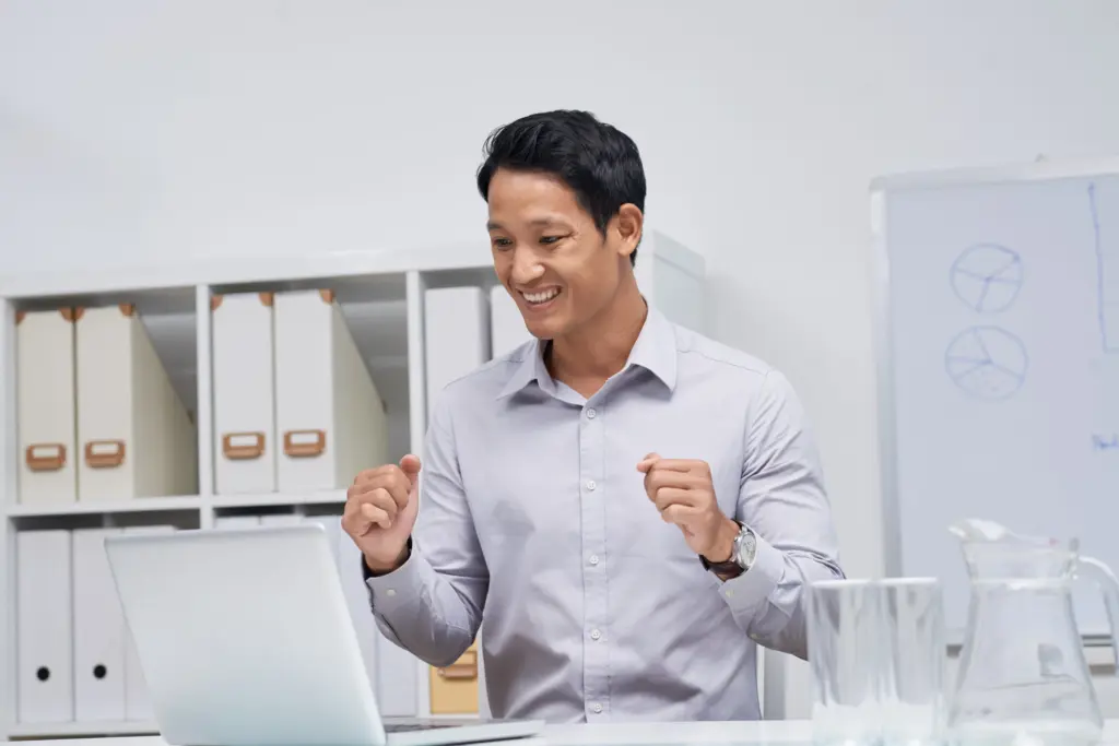 waist up portrait asian businessman sitting office desk looking laptop screen (1)