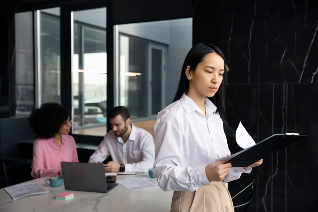woman reading documents work while her colleagues are using laptop (1)
