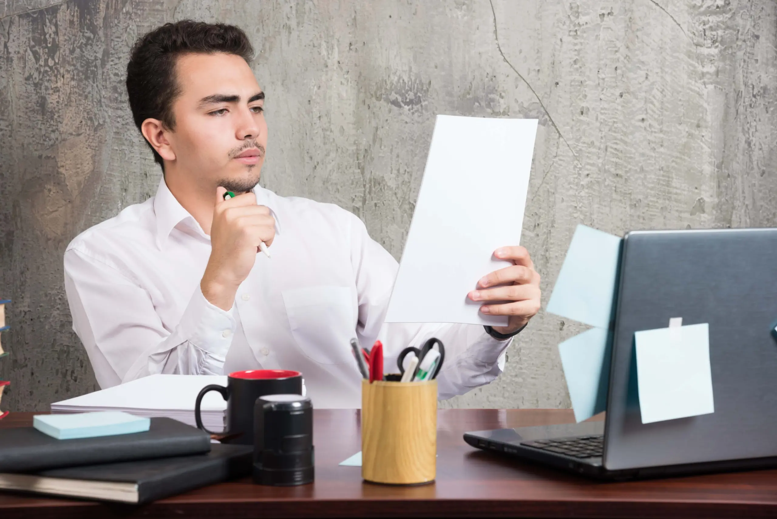 young businessman looking work papers office desk (1)