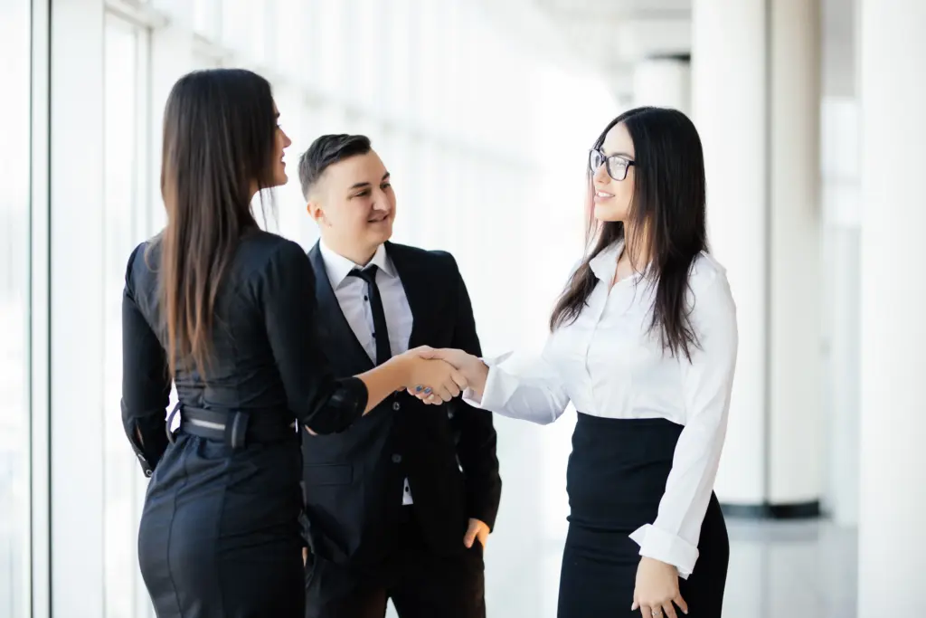 business partners shaking hands meeting hall two business woman greetings handshake office (1)