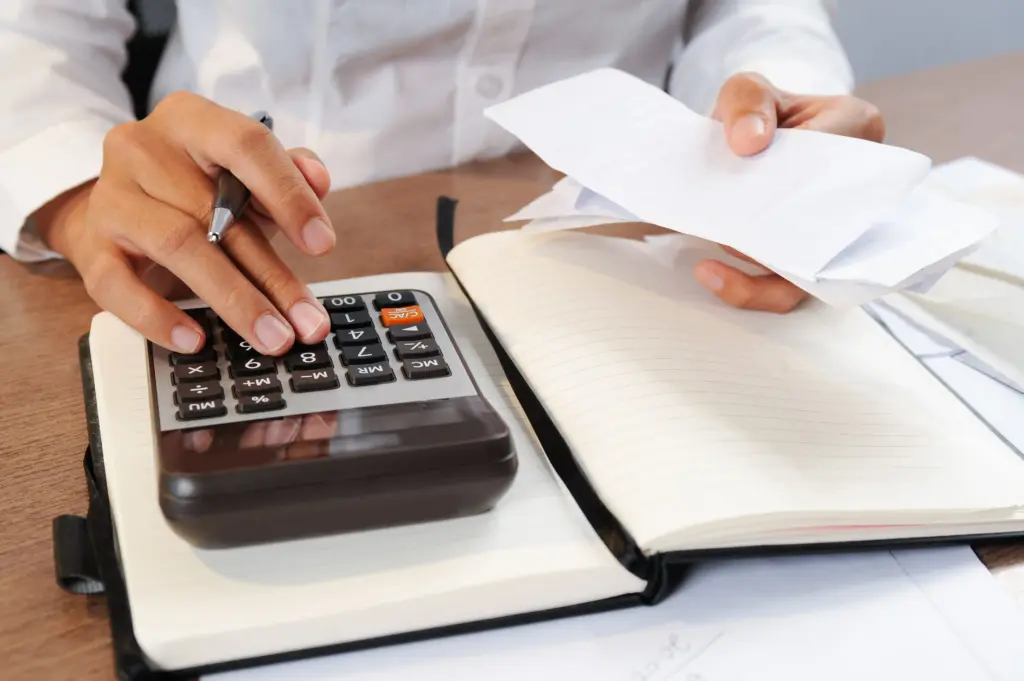 closeup person calculating bills calculator (1)