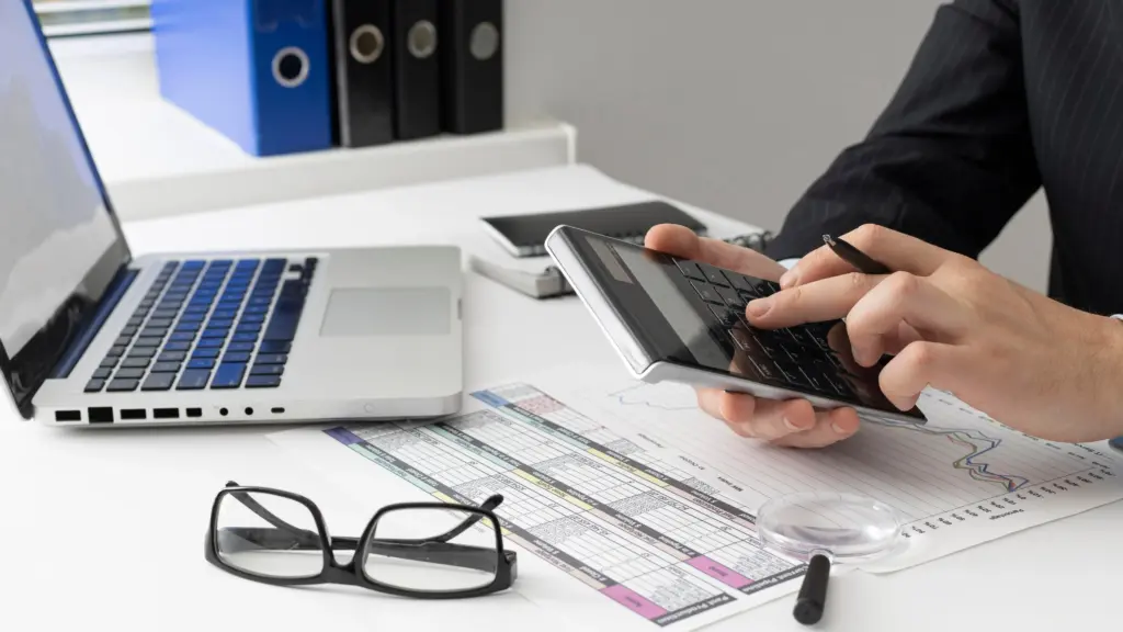 side view business man calculating finance numbers (1)