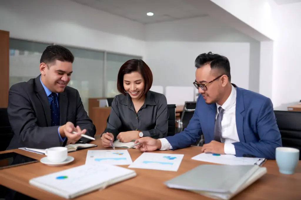 multiethnic male female colleagues sitting office discussing charts meeting (1)