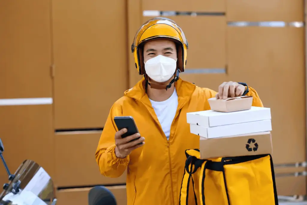 smiling courier with stacked deliveries (1)